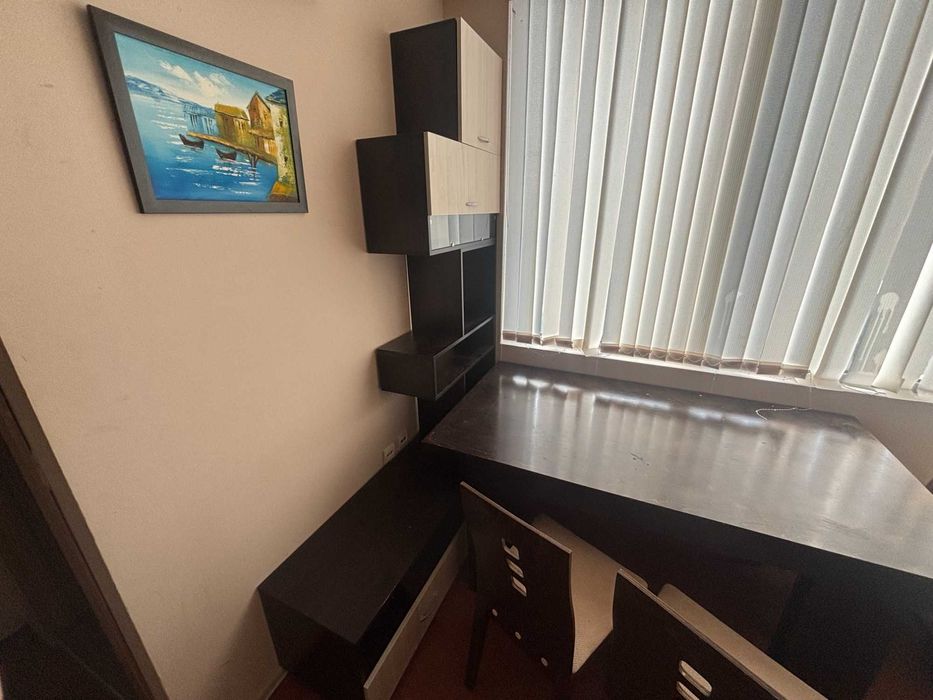 Кухненско обзавеждане с мивка и смесител, маса с три стола и секция