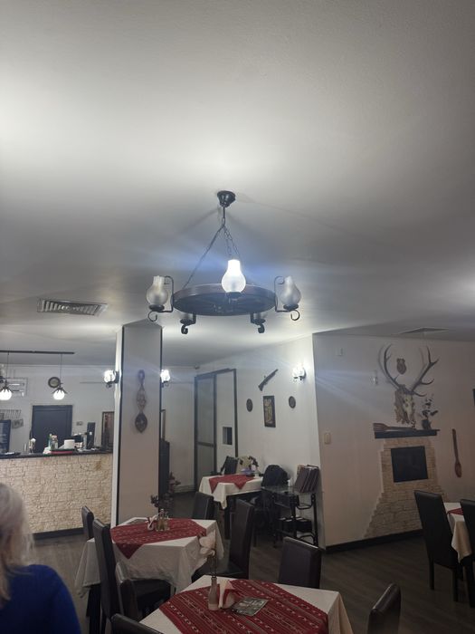 Mese , scaune , candelabre rustice , decoratiuni restaurant , semineu