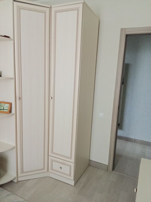 Шкаф угловой светлого цвета  вместе с пеналом и угловыми полкамии