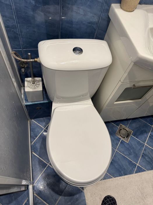 Мивка за баня с шкафче и тоалетна чиния .