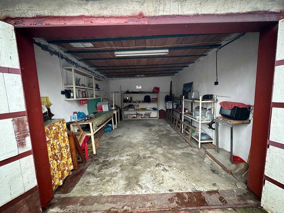 Vand garaj echipat cu rafturi metalice și uși metalice.