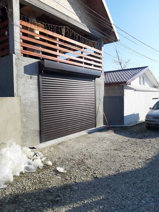 Uși garaj, rulou, acționate electric și sistem manual.