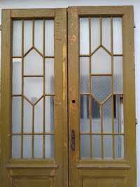 Geamuri ferestre vechi din metal încastrate în ușă de lemn