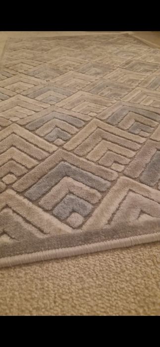 Covor cu motive  dungate si culori calde.