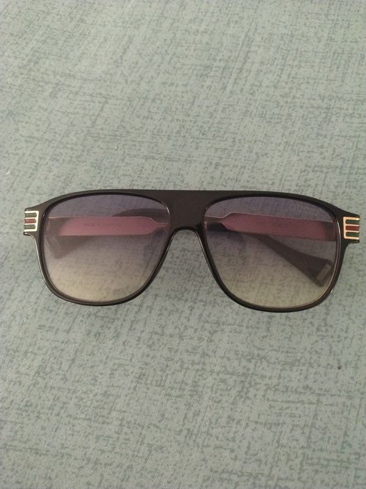 Ochelari de soare unisex cu ramă metalică aurie și detalii colorate.