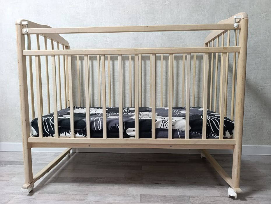 Детская кроватка из натурального дерева.