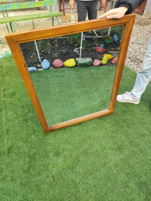 Oglinda cu ramă din lemn masiv.