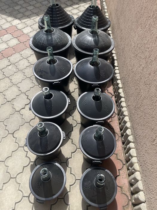 Damigeană din sticlă cu coș din plastic .