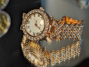 Страхотен дамски позлатен часовник с множество камъни.