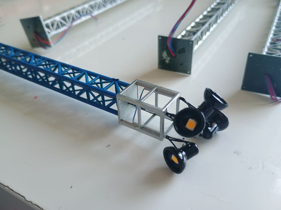 Stâlpi de iluminat industriali, reflectoare, machetă trenuleț electric