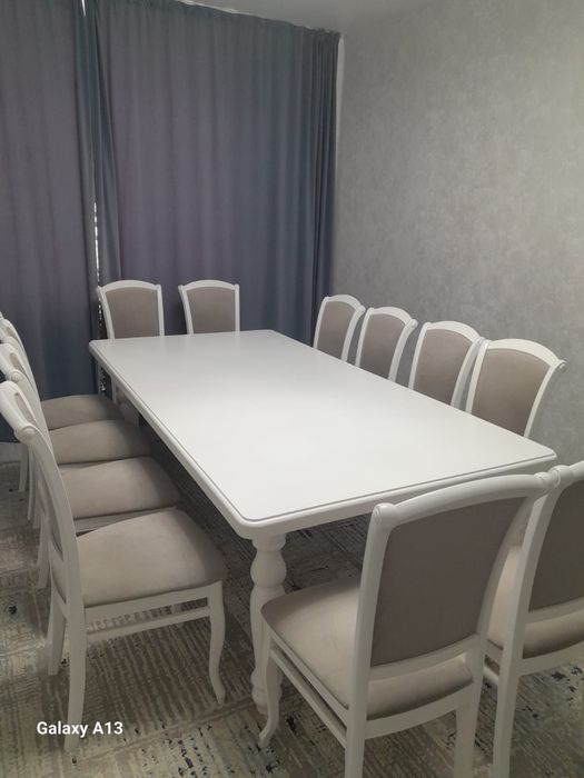 Большой удлинённый стол с стулями в гостиной