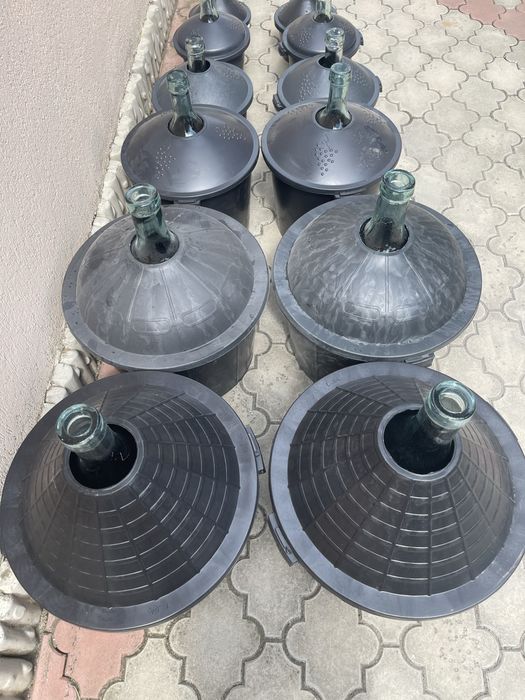 Damigeană din sticlă cu coș din plastic .