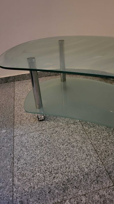 Елегантна стъклена маса с елипсовидна форма,на колелца