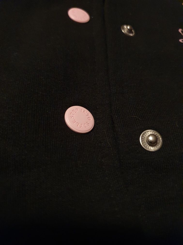 Bluza groasă neagră cu detalii roz.