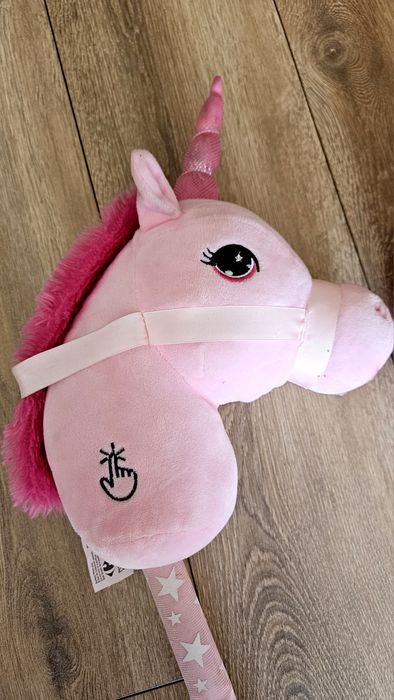 Unicorn roz de pluș pe un băț de lemn