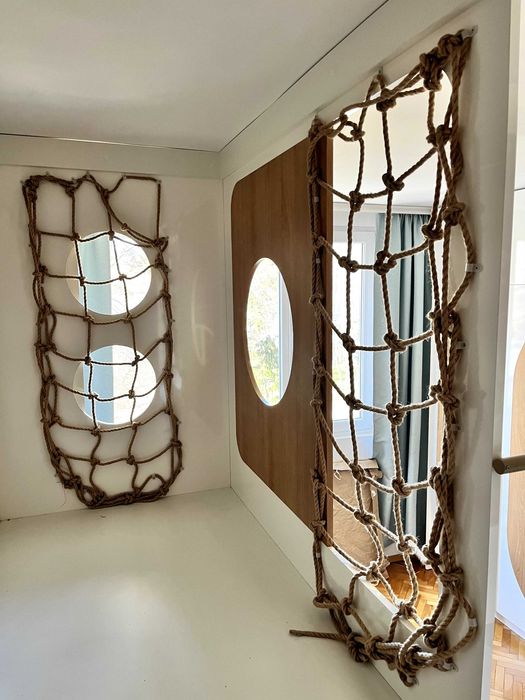 Детски легла на втори етаж със стълба, етажерки и ракли под тях