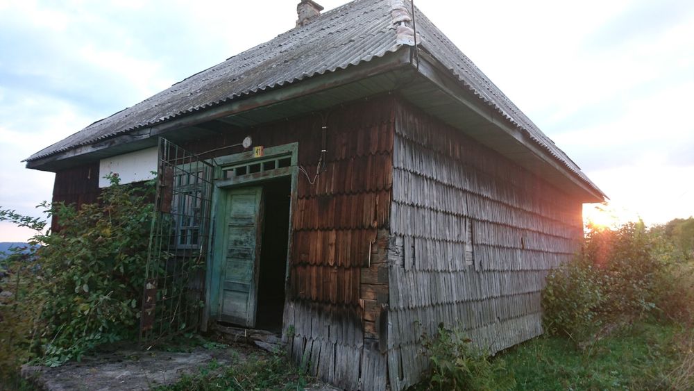 Cabană pretabilă pentru mutat din bârne groase, îmbrăcată în draniță..