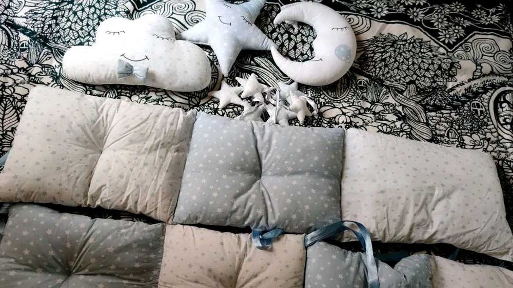 Обиколник за кошара в синьо и бяло с няколко декоративни възглавнички.