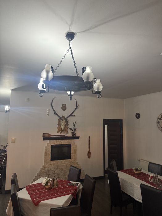 Mese , scaune , candelabre rustice , decoratiuni restaurant , semineu