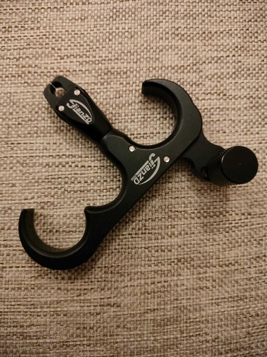 Declansator "thumb release" pentru arc compound