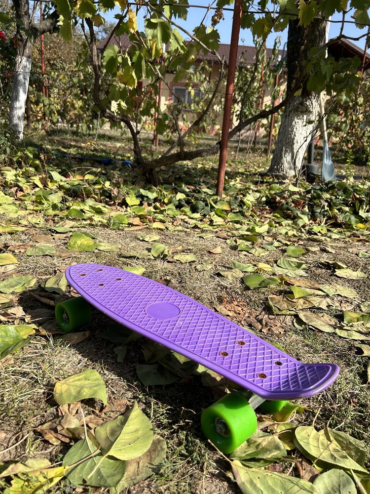 Penny board cu placa mov si roti verzi