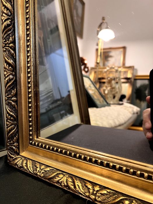 Oglinda veche încadrată in rama realizată din lemn.