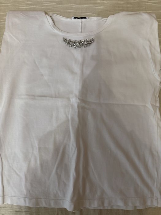 Бяла тениска с камъни и подплънки под ръкава