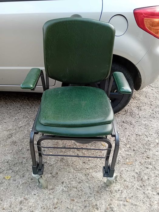 Scaun wc masiv pe roti verde.