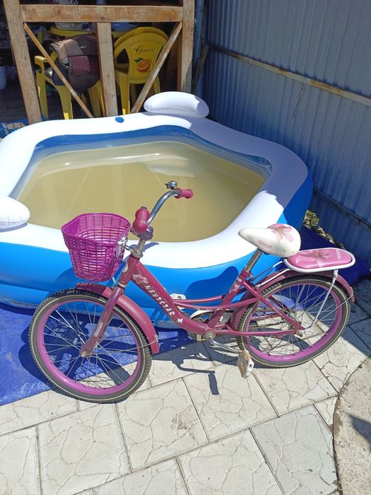 Детский велосипед с дополнительными маленькими колёсиками .