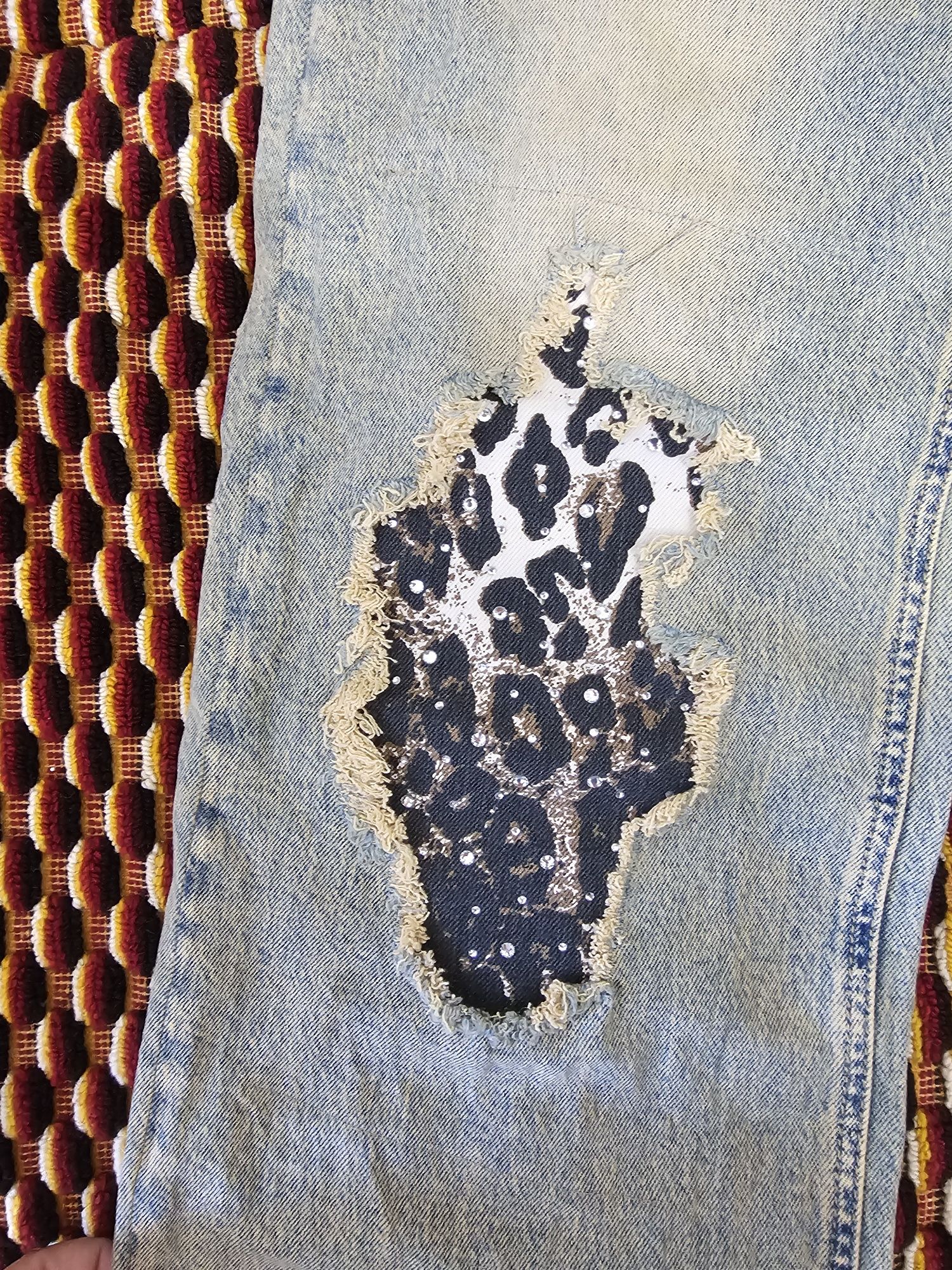 Blugi din denim de un albastru uzat cu rupturi  și animal print