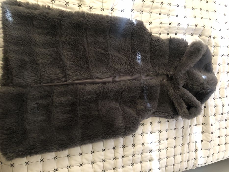 Пухен елек стои много елегантно неразличим от нов.