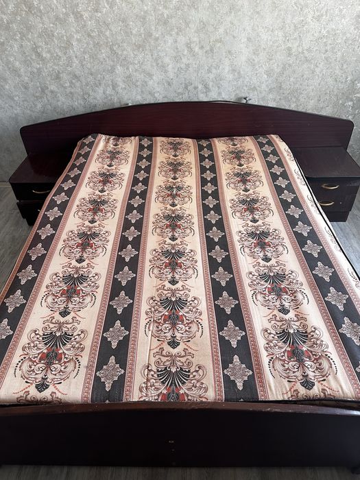 Кровать двуспальная имеет две прикроватные тумбочки