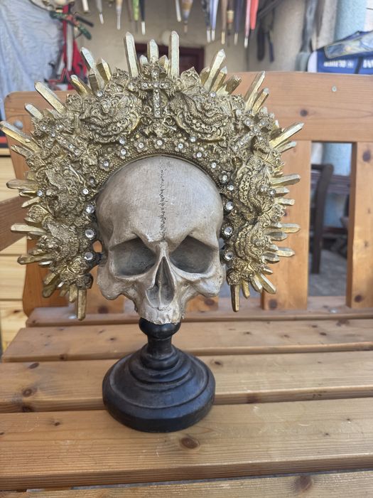 Craniu decorativ sculptata pe stativ cu coroană aurie detaliată
