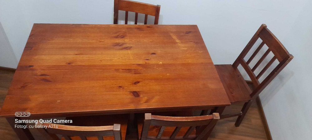 Masa de lemn cu 4 scaune, culoare maro.