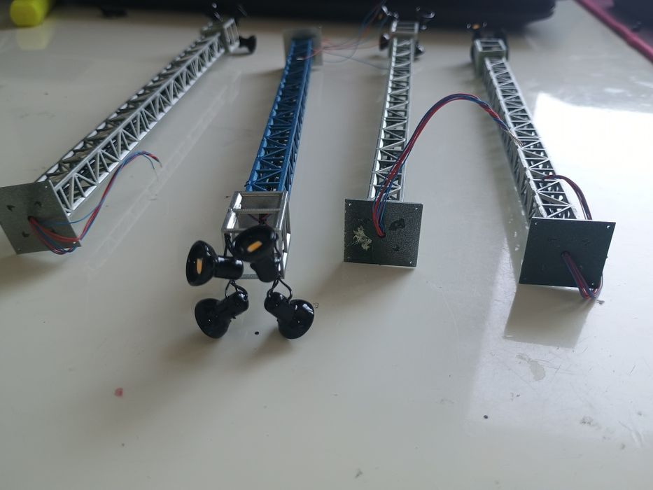 Stâlpi de iluminat industriali, reflectoare, machetă trenuleț electric